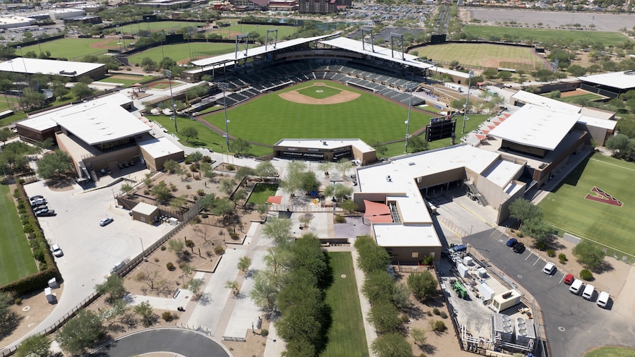 Aerial view of Salt River Fields at Talking Stick, a verdant baseball stadium nestled among the arid landscape, a striking contrast against the distant mountains, Scottsdale, Arizona, United States.