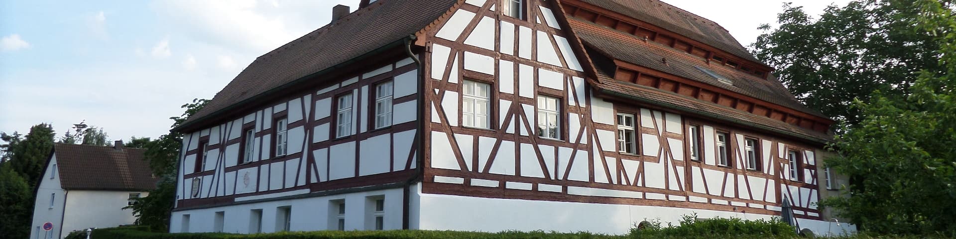 A traditional half-timbered house with a steeply pitched roof and a chimney.