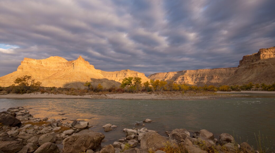 Sunlight shining through the clouds on desert landscape of Grays Canyon as the Green River flows past Swasey's Beach.