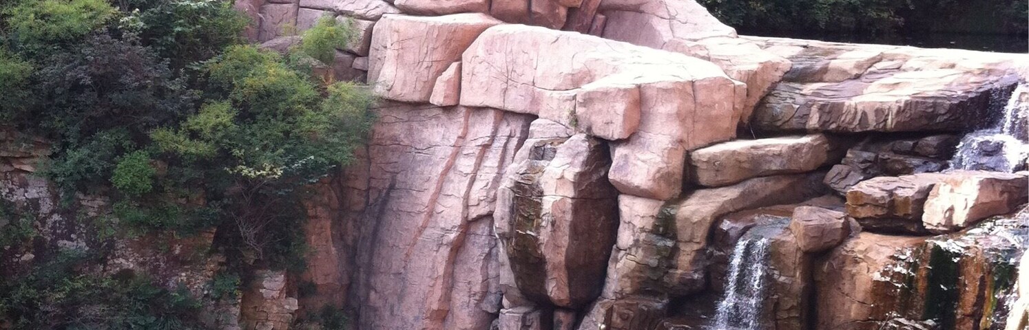 A large rock formation with a waterfall.