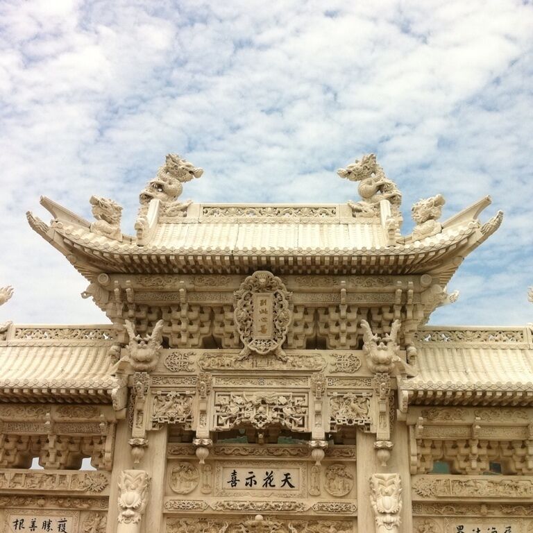 A traditional Chinese gate with intricate carvings and lion statues.