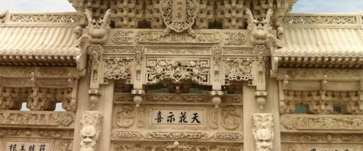 A traditional Chinese gate with intricate carvings and lion statues.