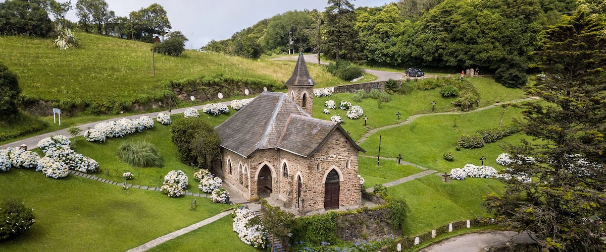 A church surrounded by a cemetery with white flowers.