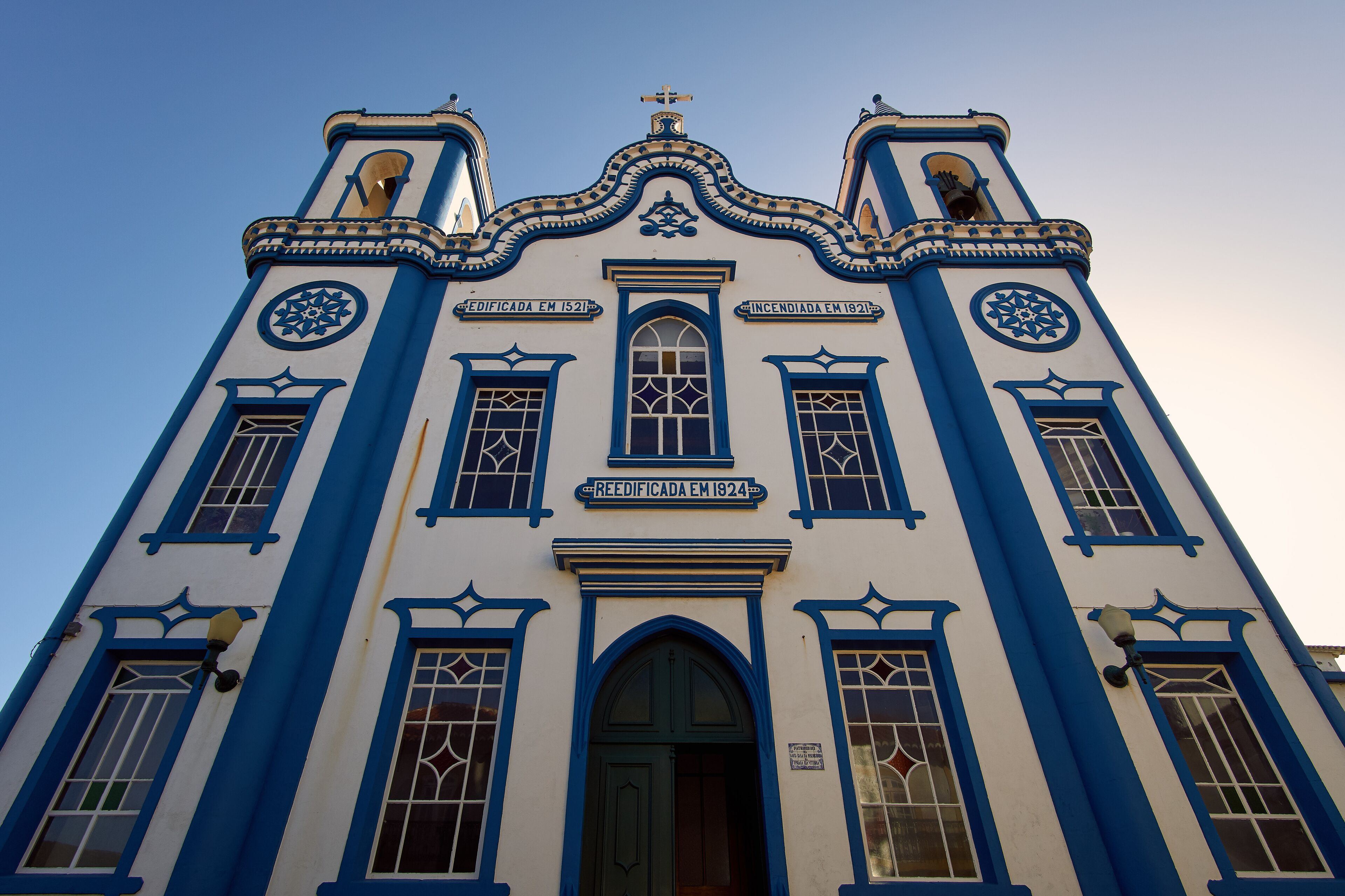 A building with blue and white exterior, three towers, and a central entrance.