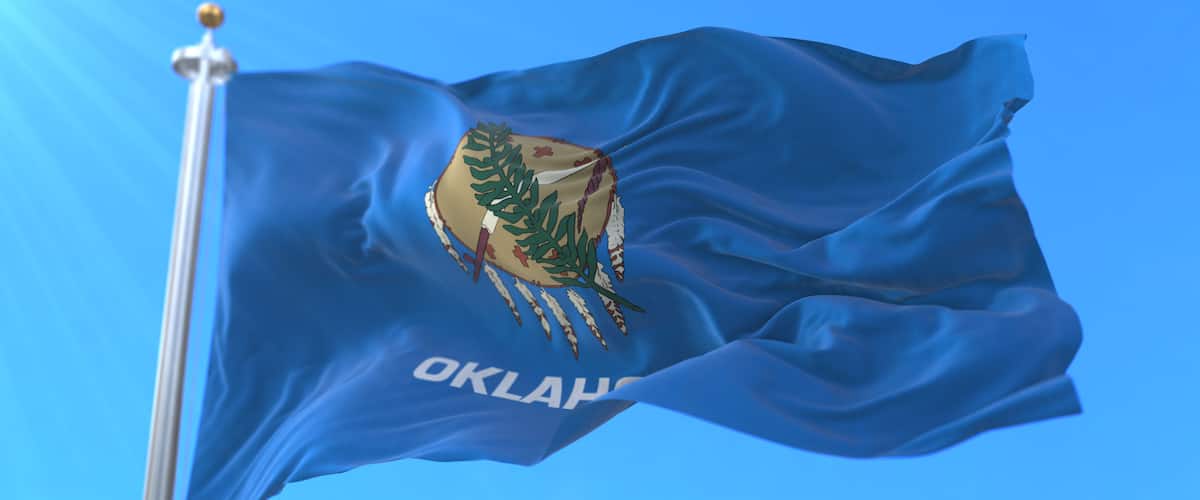 A flag with a coat of arms and the word 'OKLAHOMA' on a blue background.