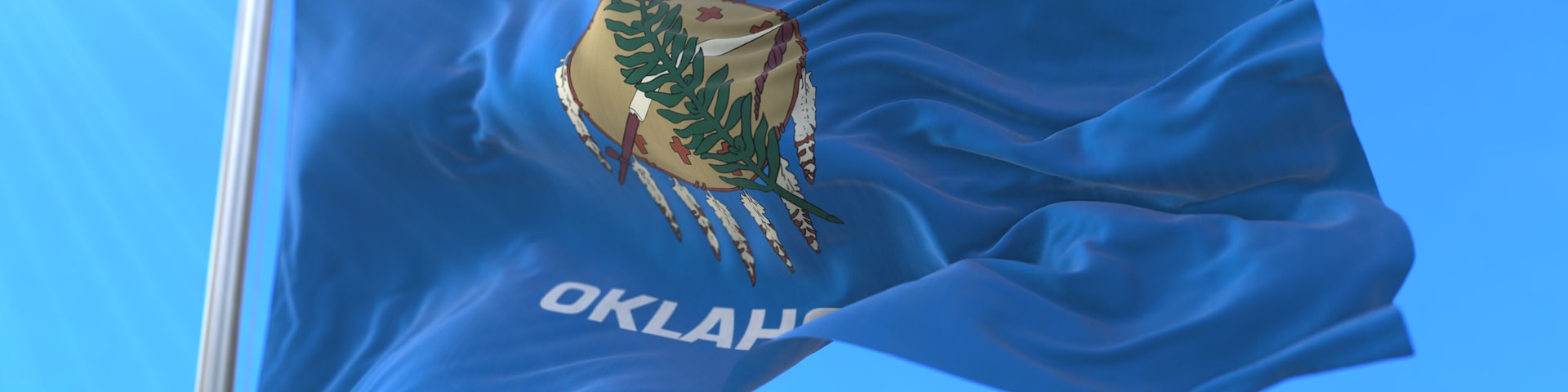 A flag with a coat of arms and the word 'OKLAHOMA' on a blue background.