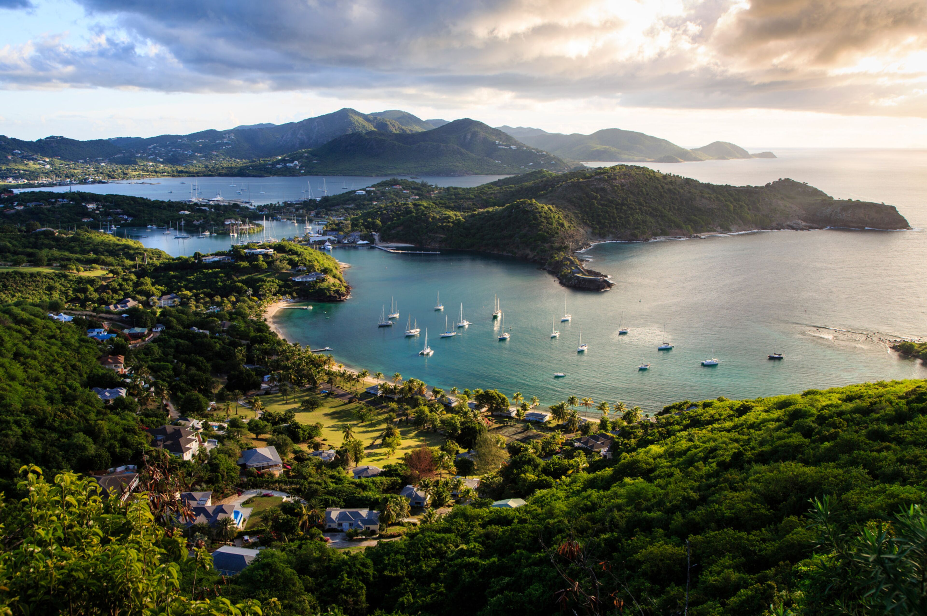 Uma cidade costeira com casas, barcos e vegetação exuberante.