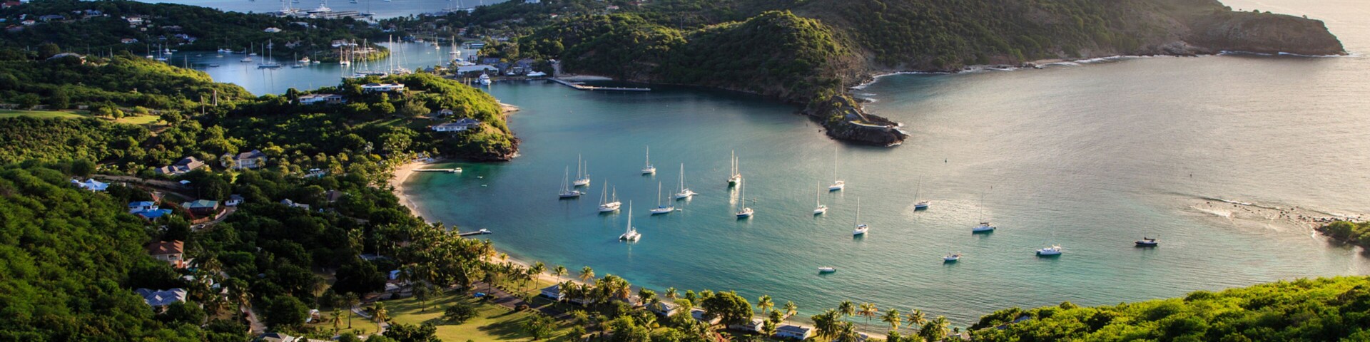 Uma cidade costeira com casas, barcos e vegetação exuberante.