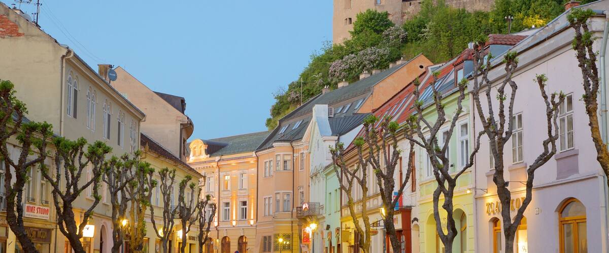 A cobblestone street lined with colorful buildings and bare trees.