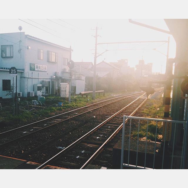 Railway tracks, a building with the number 25, and a distant cityscape.