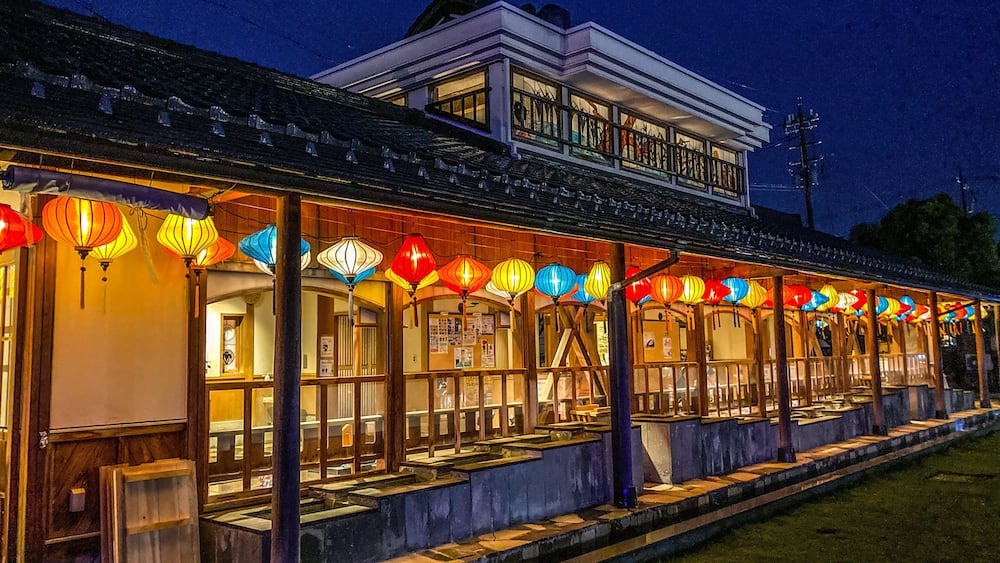 Ein traditionelles Gebäude mit einem Balkon, verziert mit bunten Laternen.
