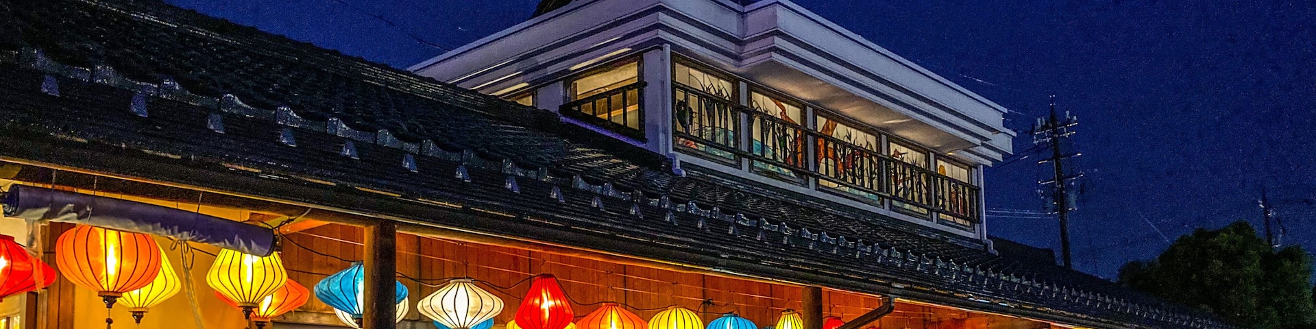 A traditional building with a balcony, adorned with colorful lanterns.