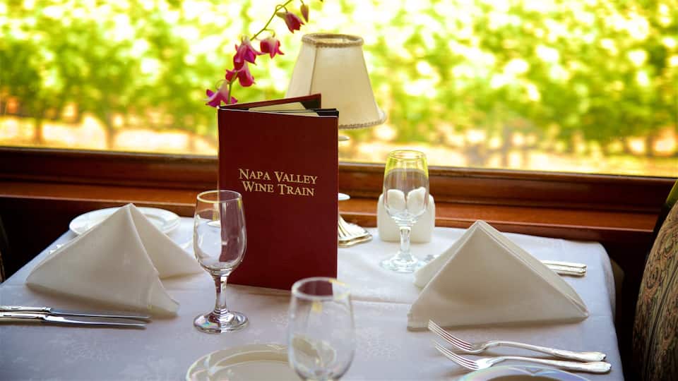 A table set for a meal with a menu titled "Napa Valley Wine Train" and a view of vineyards in the background.