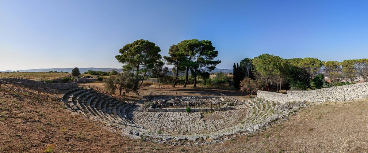 Ancient stone ruins with terraced seating and a stone wall.