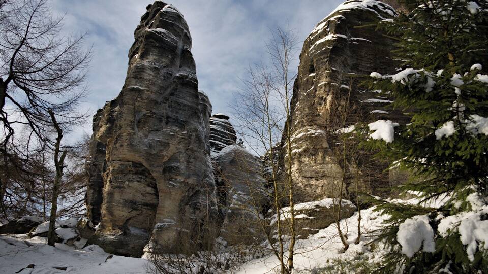 Snow-covered rock formations and trees in a winter landscape.