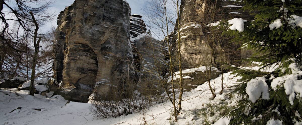 Snow-covered rock formations and trees in a winter landscape.