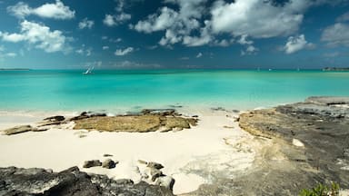 A turquoise sea, a white sandy beach, and rocky outcrops.