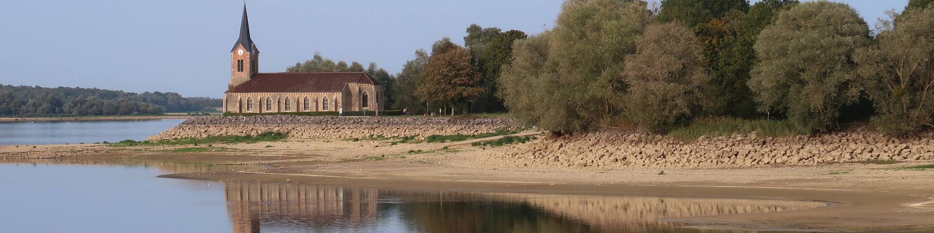 Paysage au lac du Der Chantecoq, en Champagne Ardenne, dans la région Grand Est, avec l’église de Champaubert et des arbres se reflétant dans l’eau (France)
