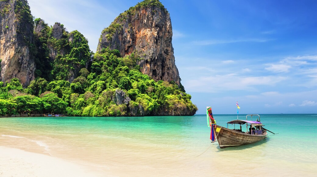 Thai traditional wooden longtail boat and beautiful sand Railay Beach in Krabi province. Ao Nang, Thailand.