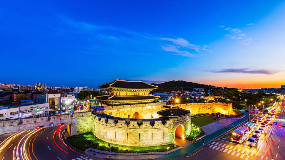A historic fortress with traditional architecture, surrounded by a modern cityscape and busy roads.