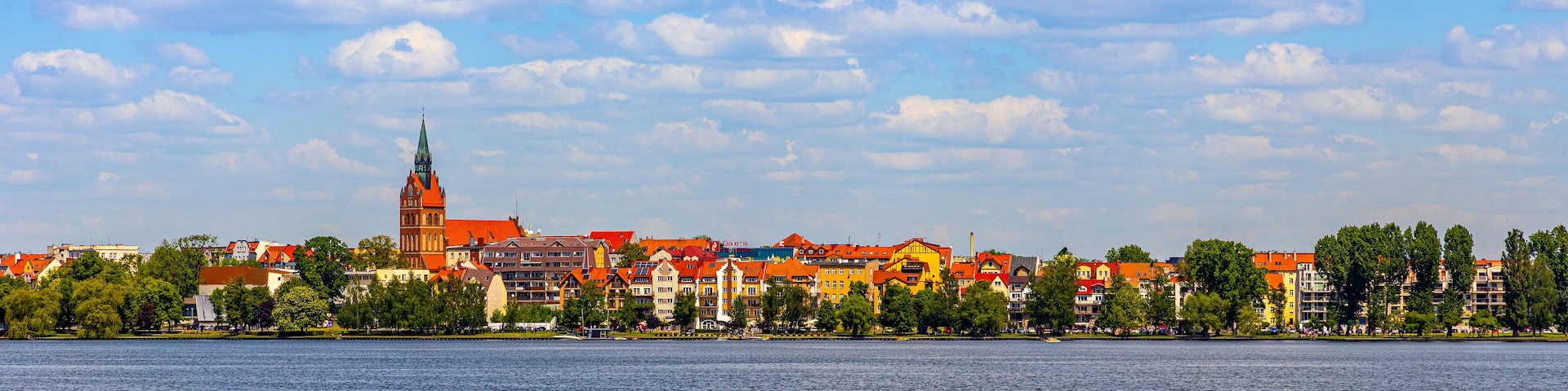 Panorama of Elk historic city center with Holiest Heart of Jesus neo-gothic church tower on shore of Jezioro Elckie lake in Masuria region in Poland