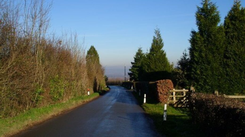 The road to Glasshouse from May Hill Village. The War Memorial is hidden from view at the junction in the centre of the photograph.