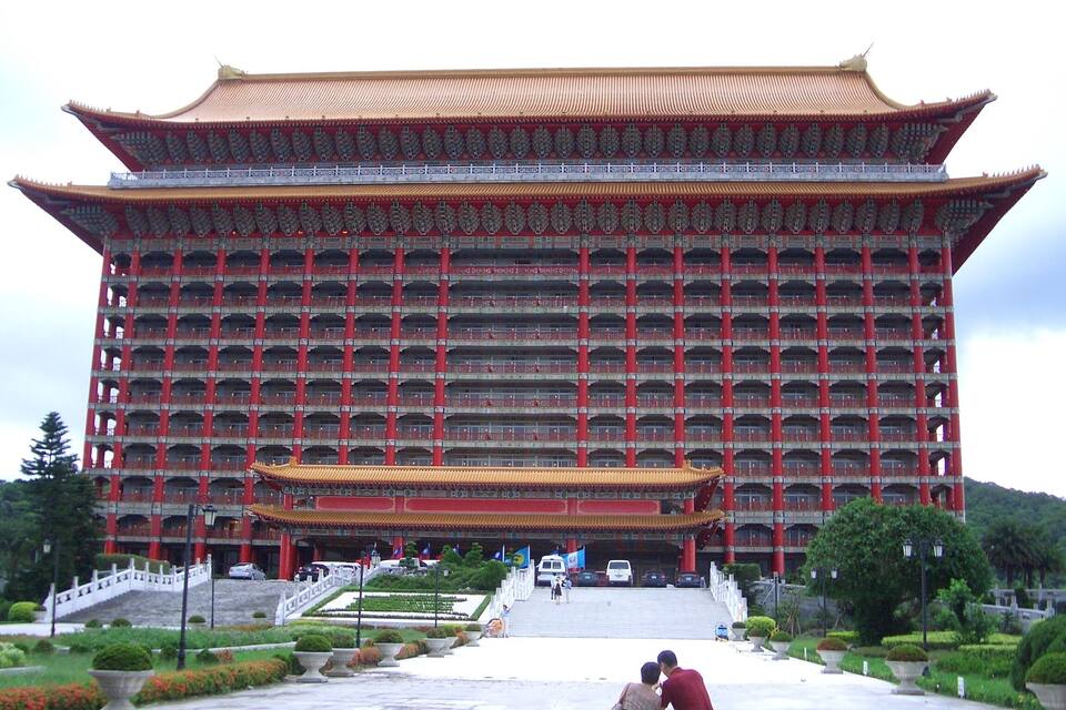 A large traditional building with multiple balconies and a red roof.