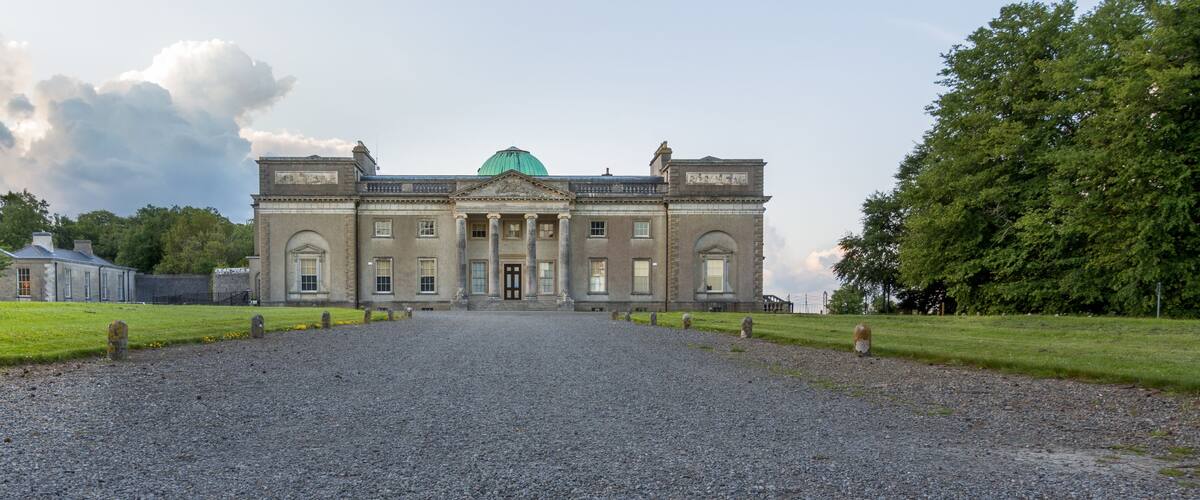 A large historic building with a green dome and classical architecture.