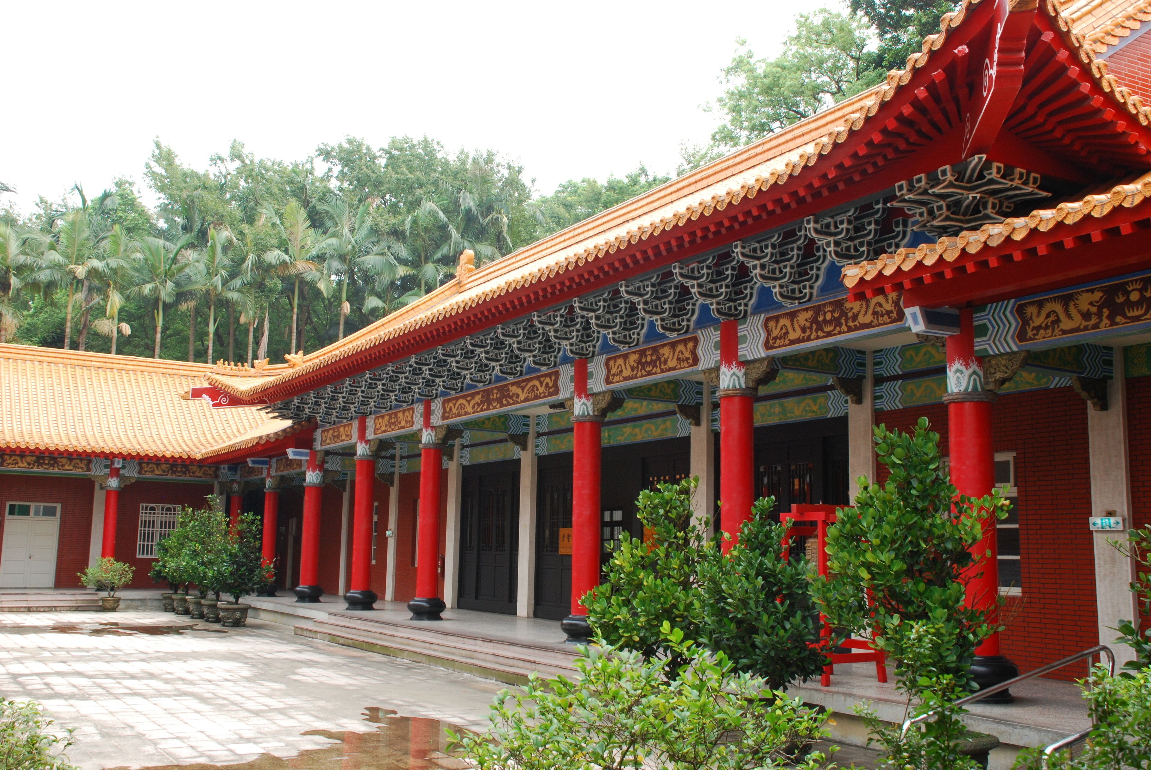 A traditional building with red columns and ornate roof tiles.