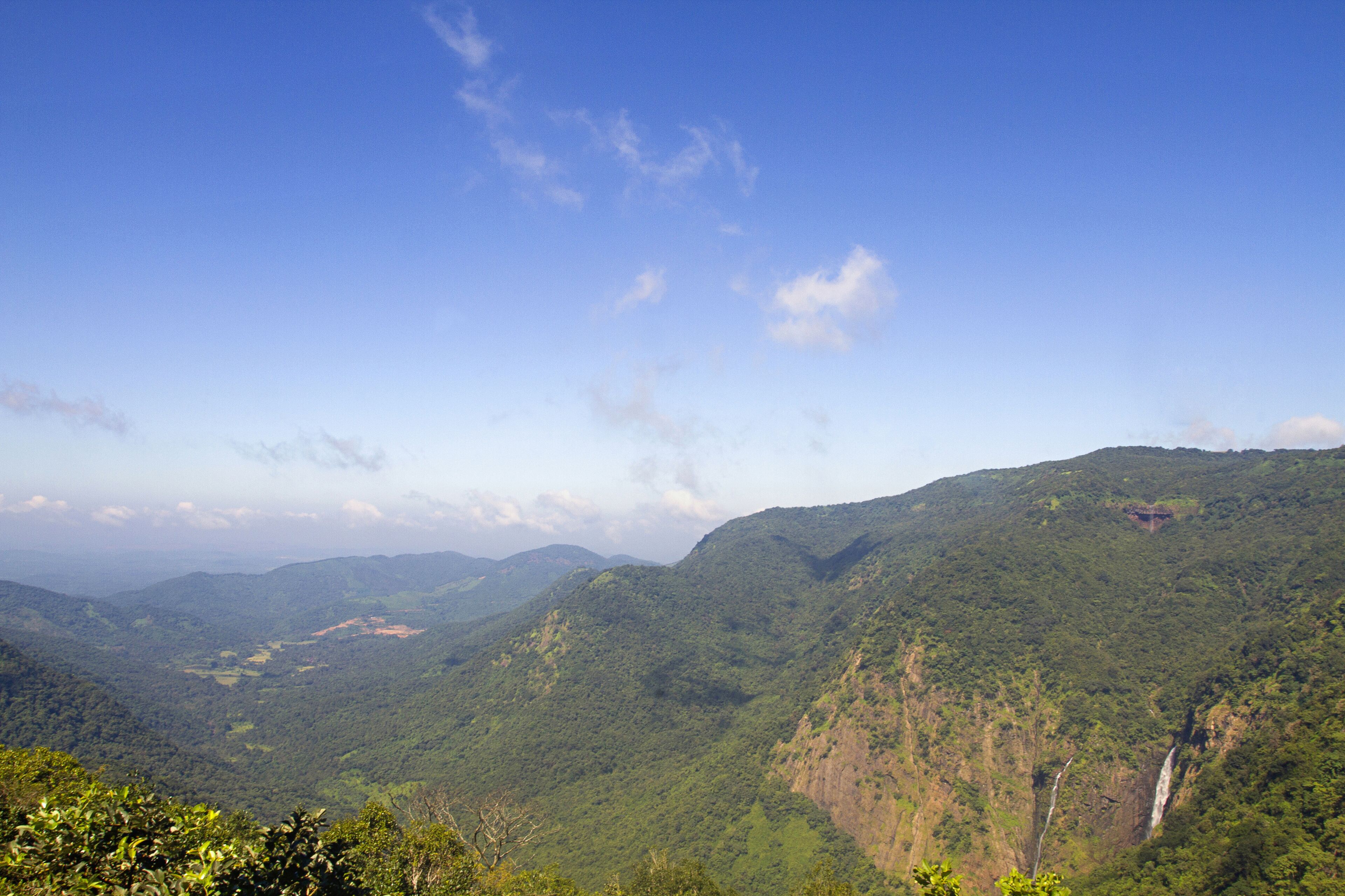 A mountainous landscape with a waterfall and lush greenery.