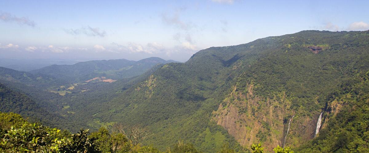 A mountainous landscape with a waterfall and lush greenery.
