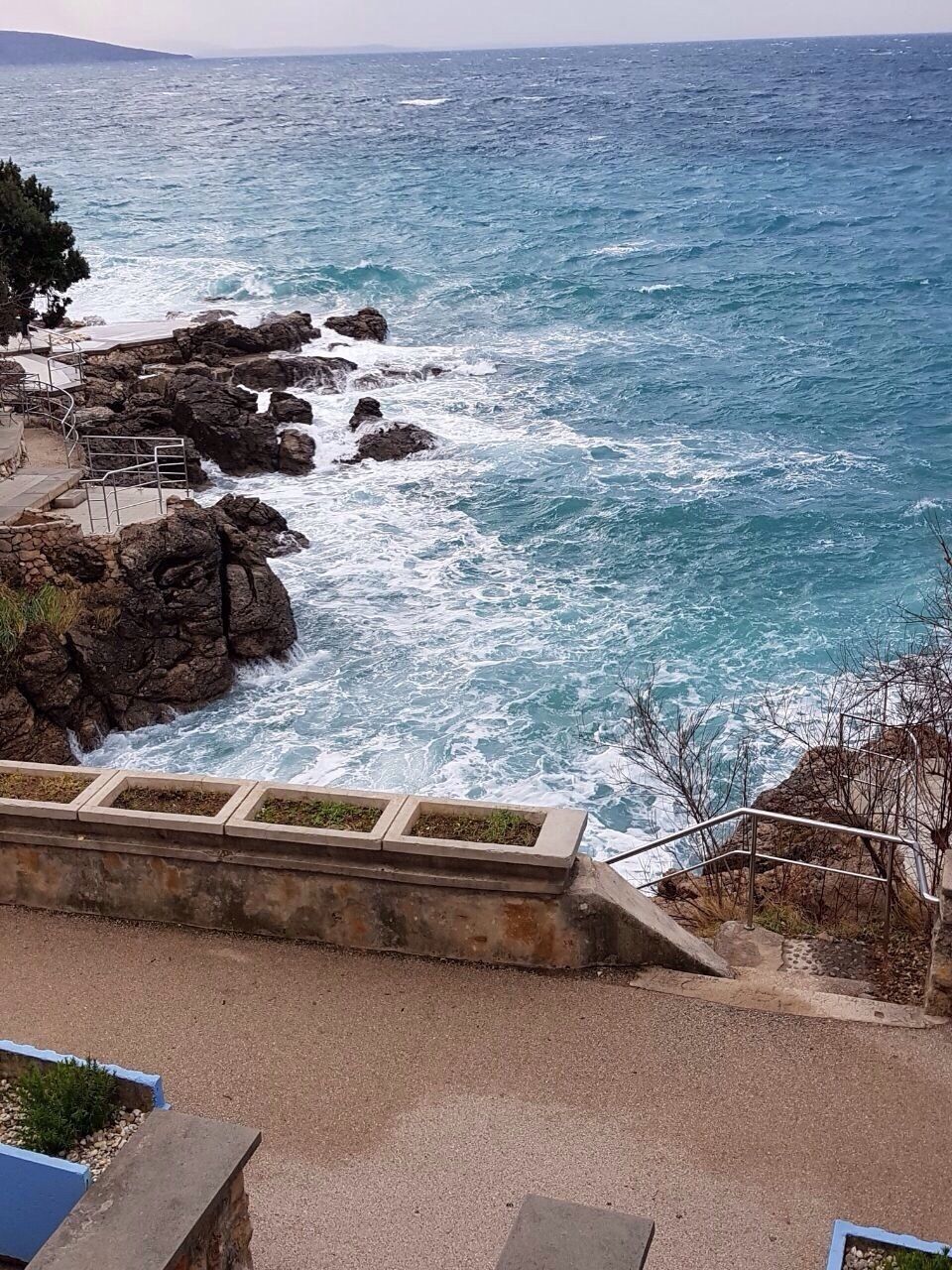 A rocky coastline with waves crashing against the shore.