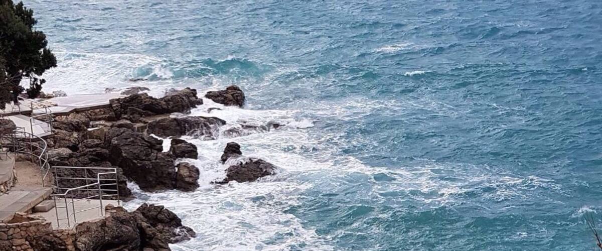 A rocky coastline with waves crashing against the shore.