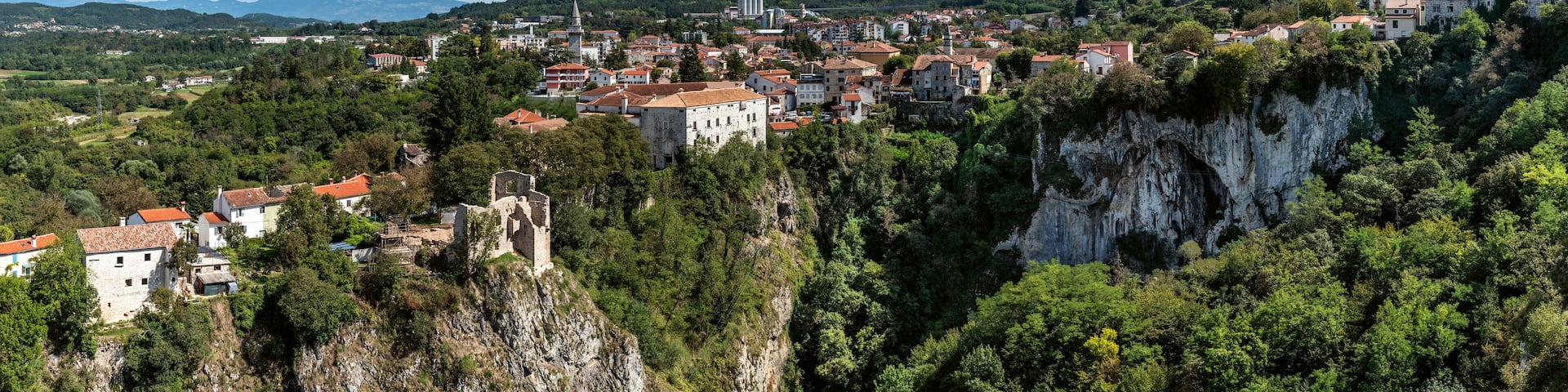 Aerial view of historic town nestled in cliff with forest, Pazinska jama, Pazin, Istria, Croatia.