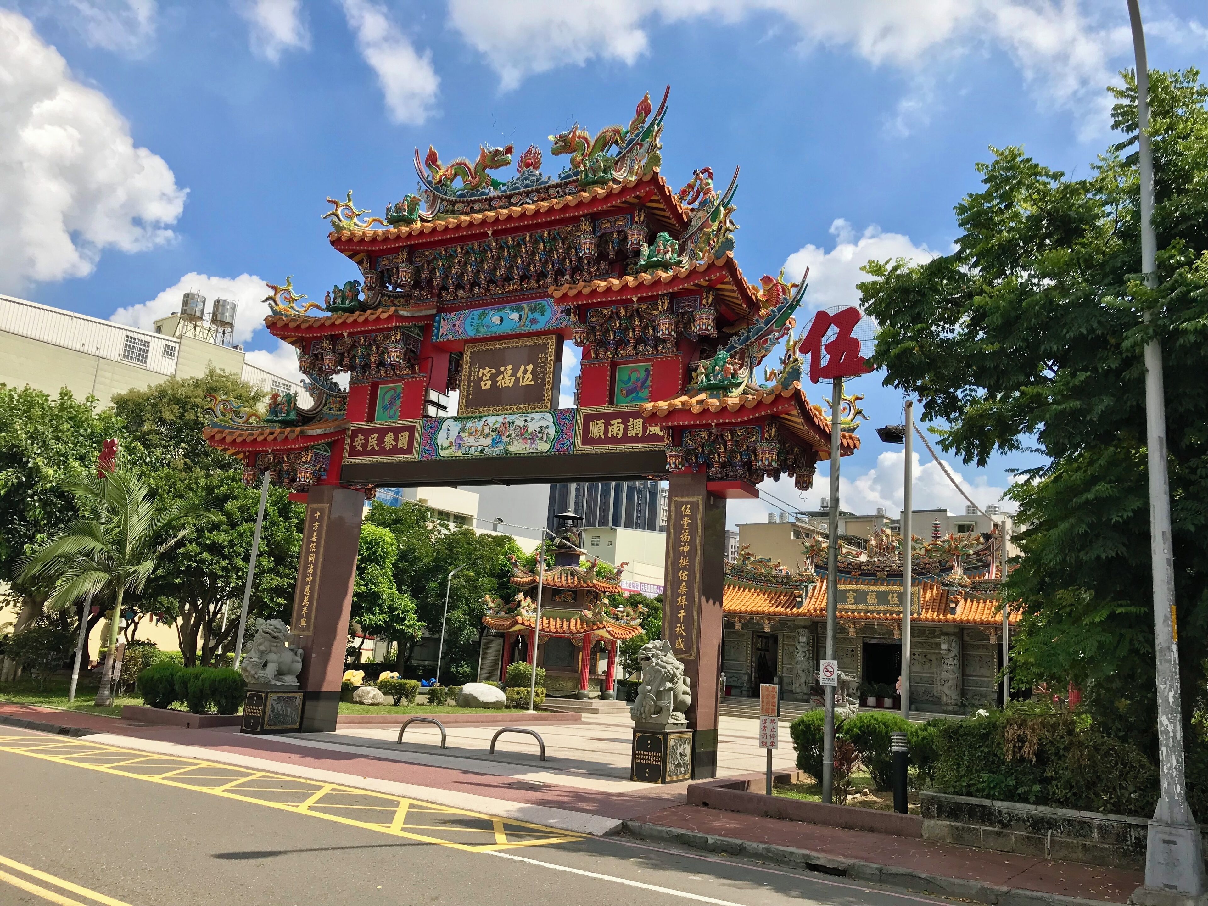 A traditional Chinese gate with intricate designs and a dragon figure on top.