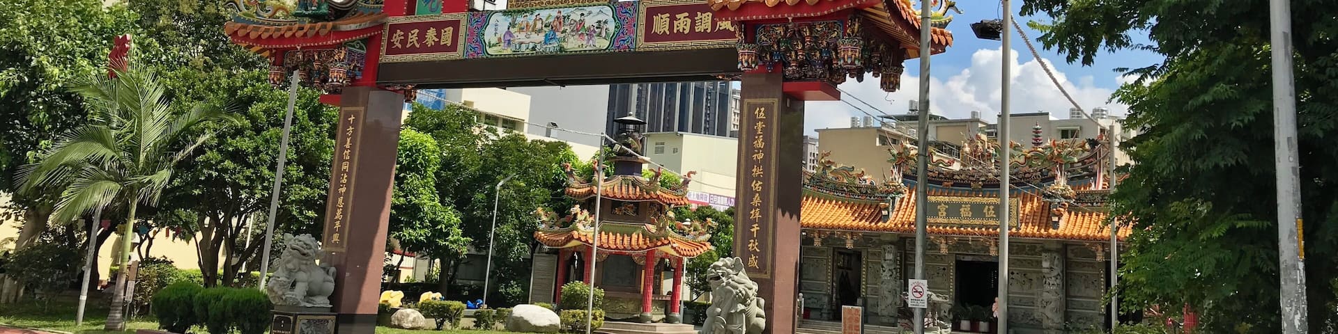 A traditional Chinese gate with intricate designs and a dragon figure on top.