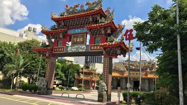 Una puerta tradicional china con diseños intrincados y una figura de dragón en la parte superior.