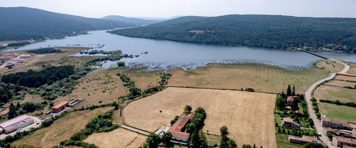 A river winding through a valley with fields and buildings.