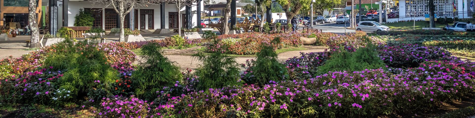 A town square with a church steeple, flower gardens, and traditional buildings.