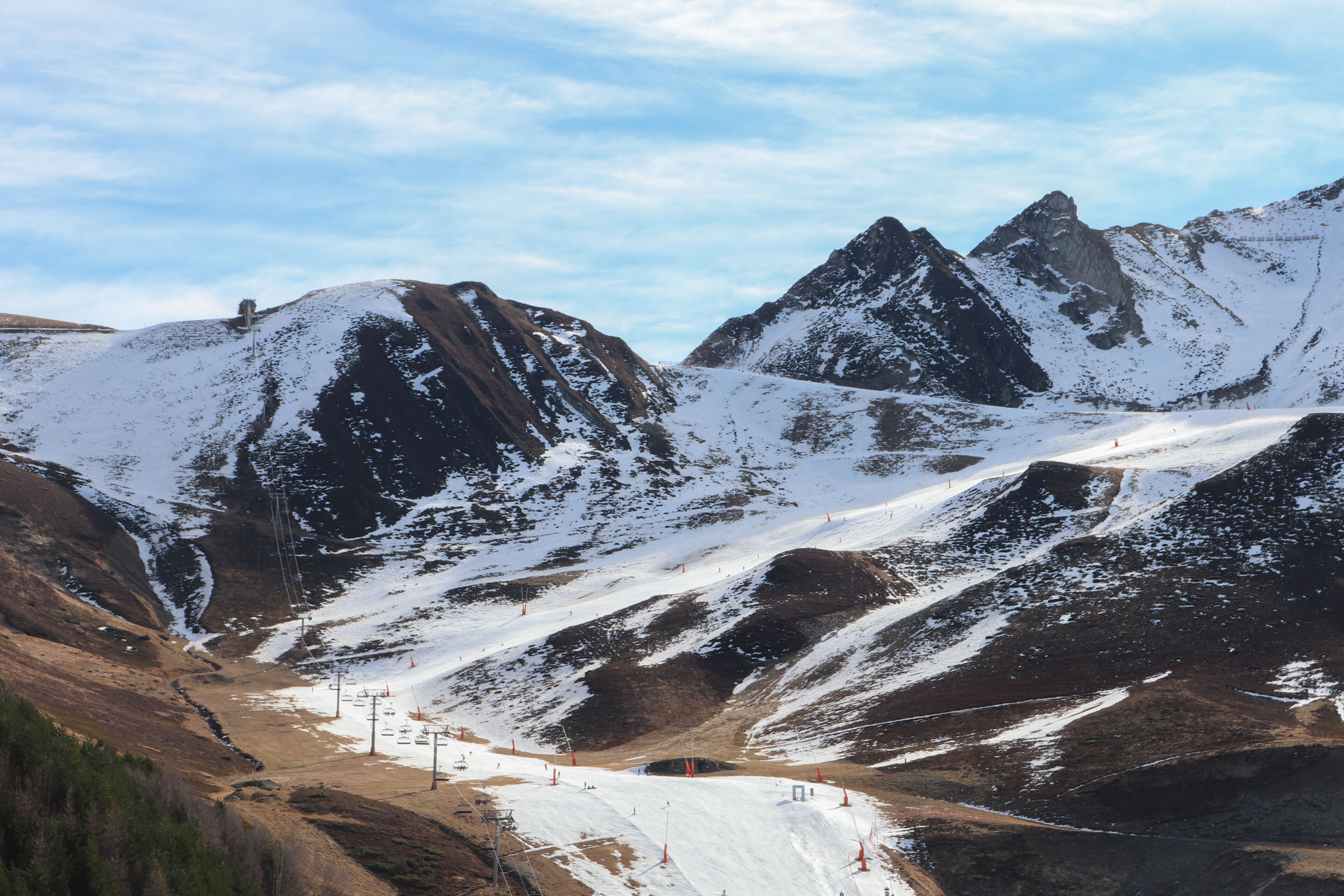 A snow-covered mountain landscape with ski slopes and a ski lift.