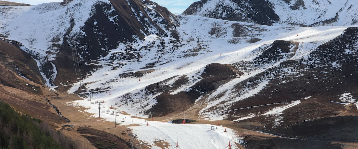 A snow-covered mountain landscape with ski slopes and a ski lift.