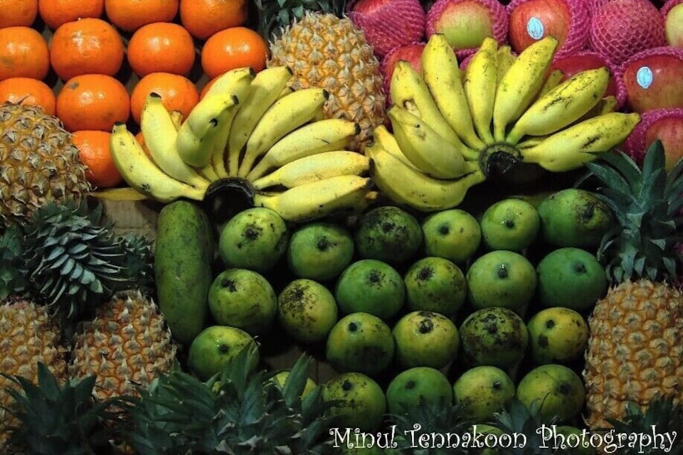 A variety of fruits including bananas, oranges, apples, and pineapples.