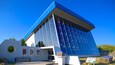 A modern building with a blue roof and reflective glass windows.