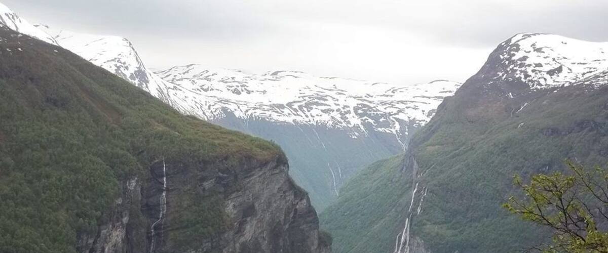 A fjord with steep cliffs and a waterfall.