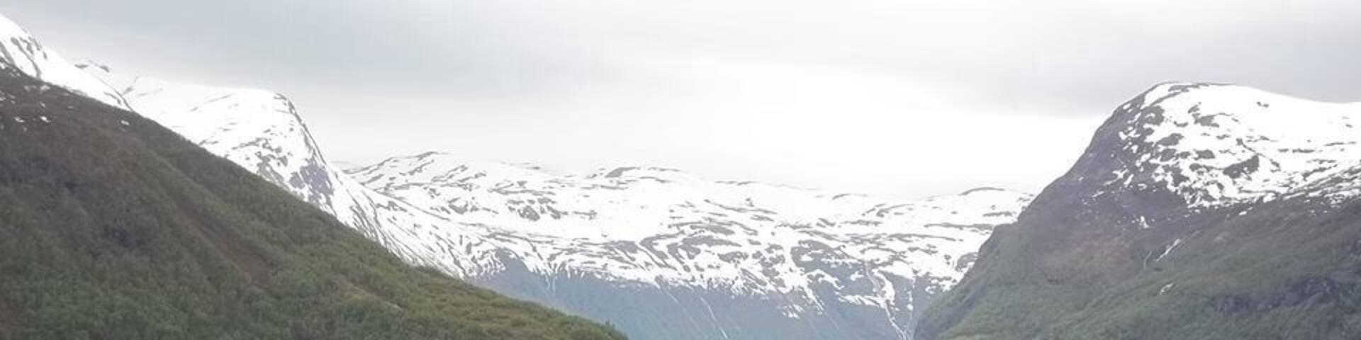 A fjord with steep cliffs and a waterfall.