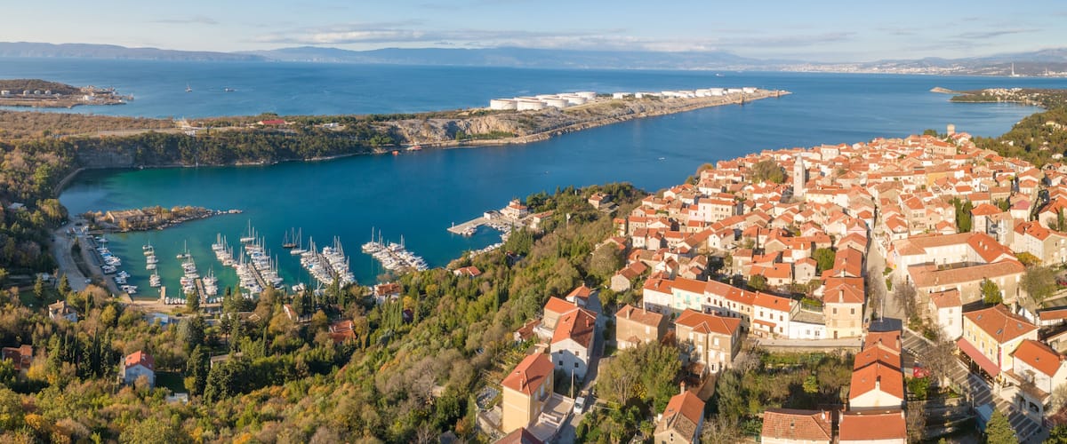 A coastal town with a marina, boats, and historic buildings.