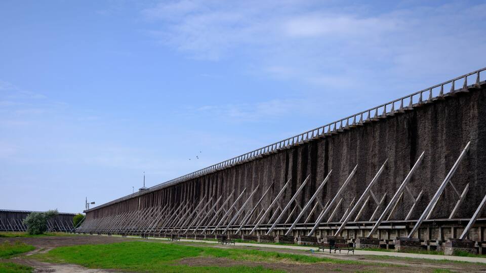 A large concrete dam with a series of metal cross braces.