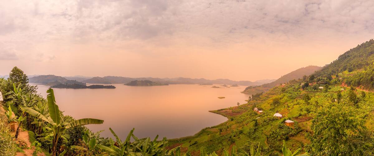A serene lake surrounded by lush greenery and hills.
