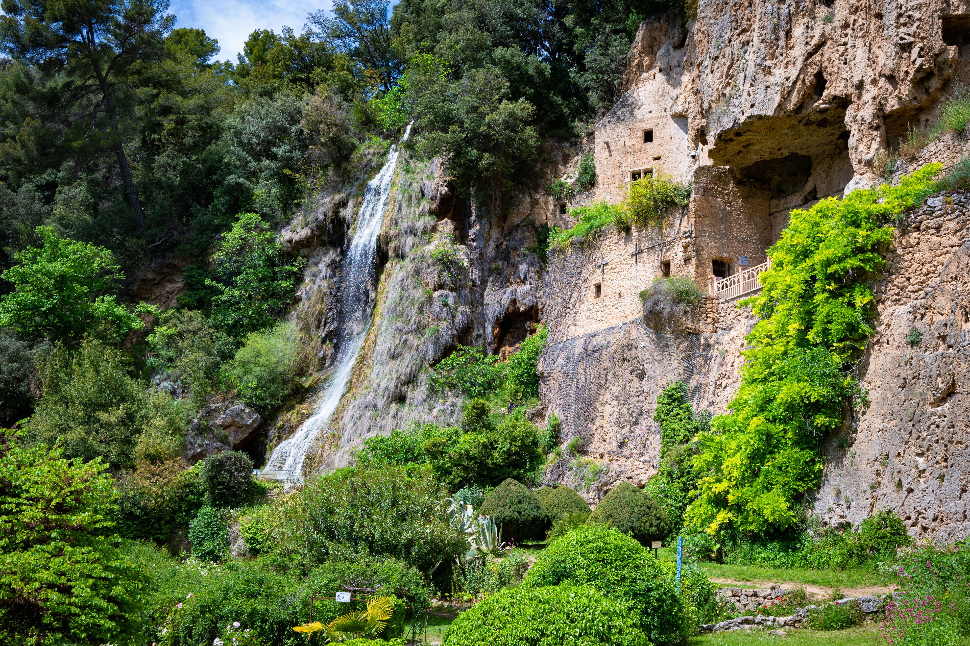 Aerial view of the beautiful Waterfall and Houses built into the cliff in the village of Villecroze France