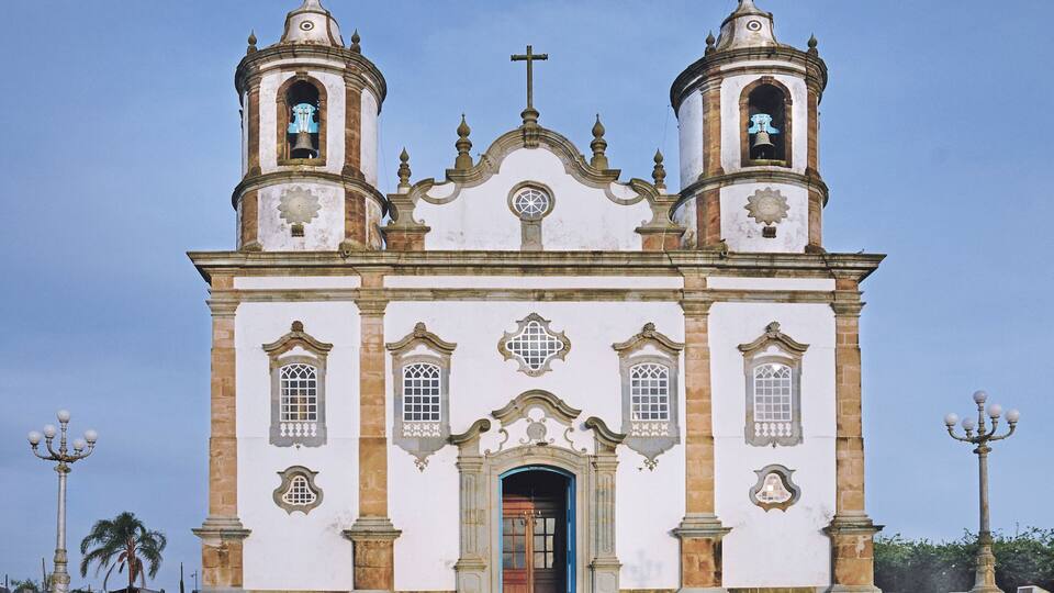 A historic church with two bell towers, a central dome, and a cross at the top.